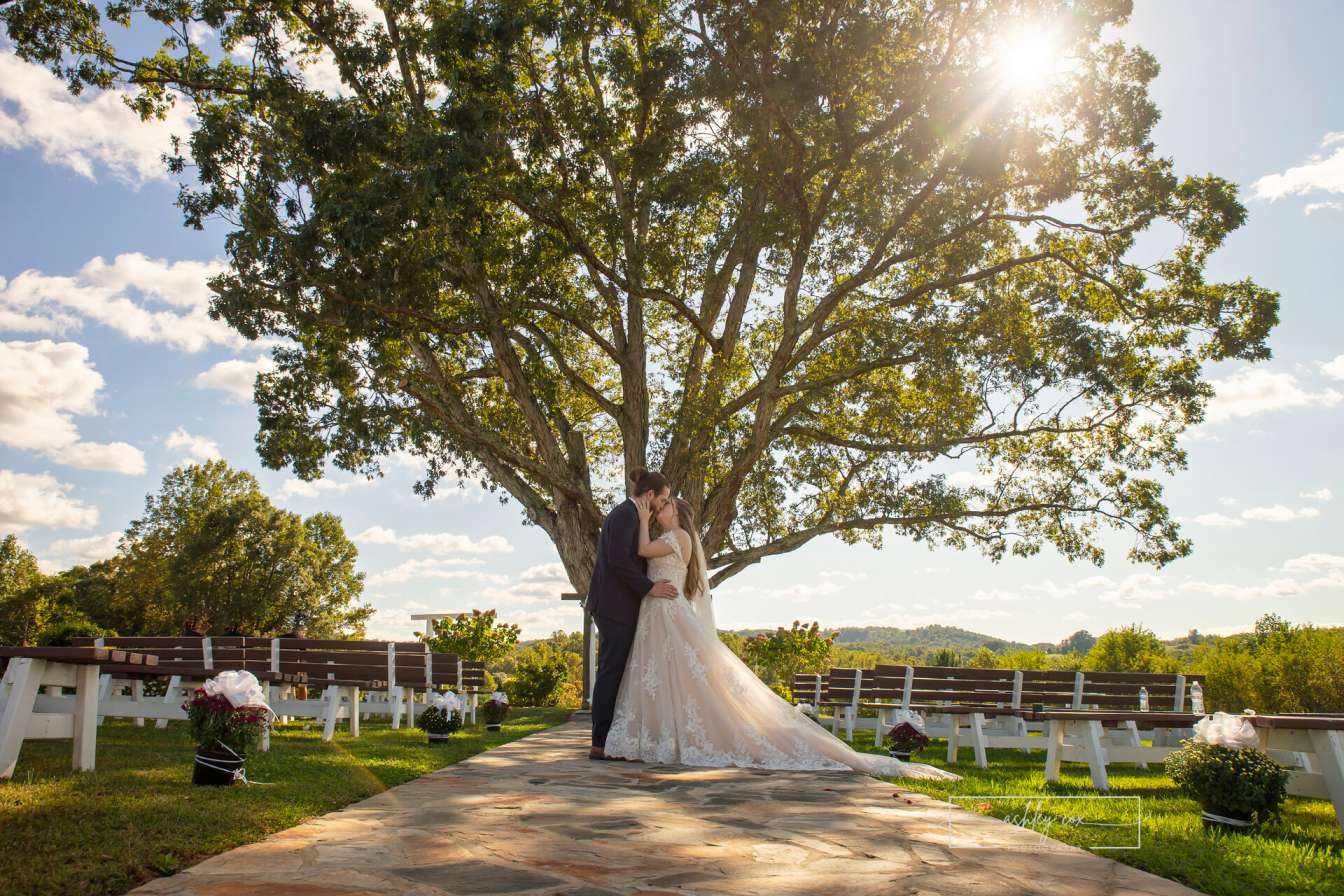 Bride and groom seated on a white swing overlooking the scenic grounds at Mayberry Meadows in Mount Airy, North Carolina